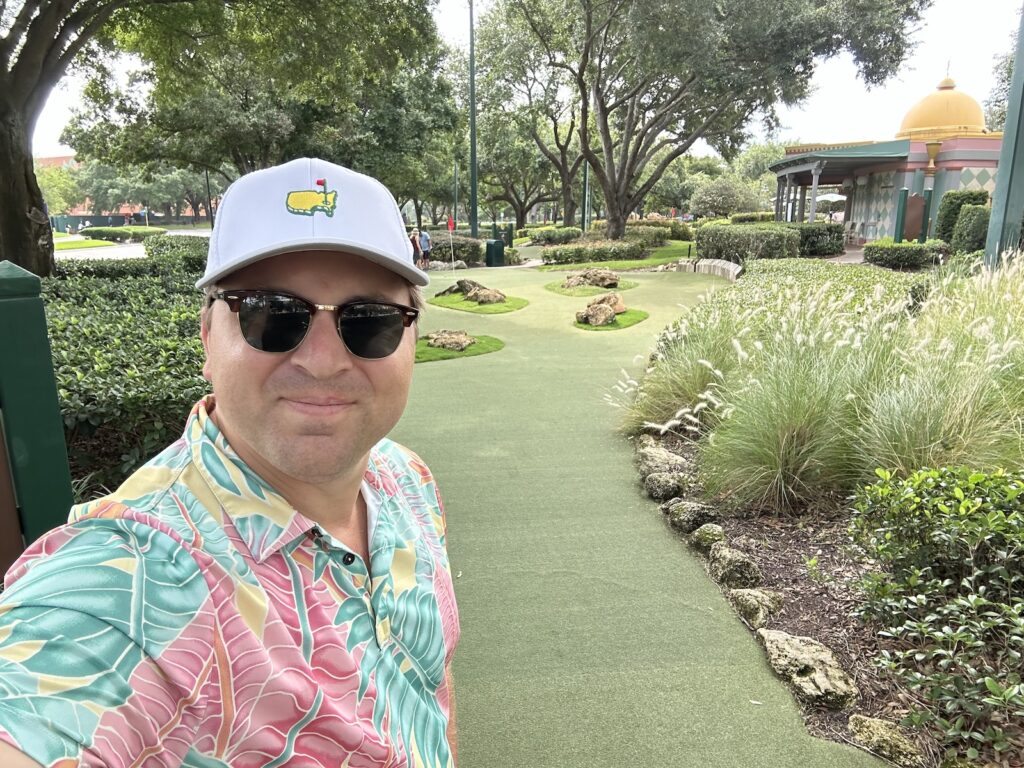 Man in Masters Hat playing mini golf at Walt Disney World